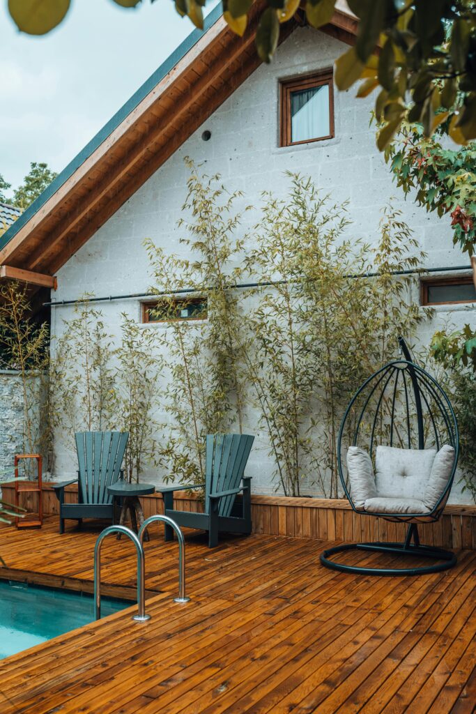 A serene terrace with pool, cozy chairs, and bamboo plants for a relaxing outdoor escape.